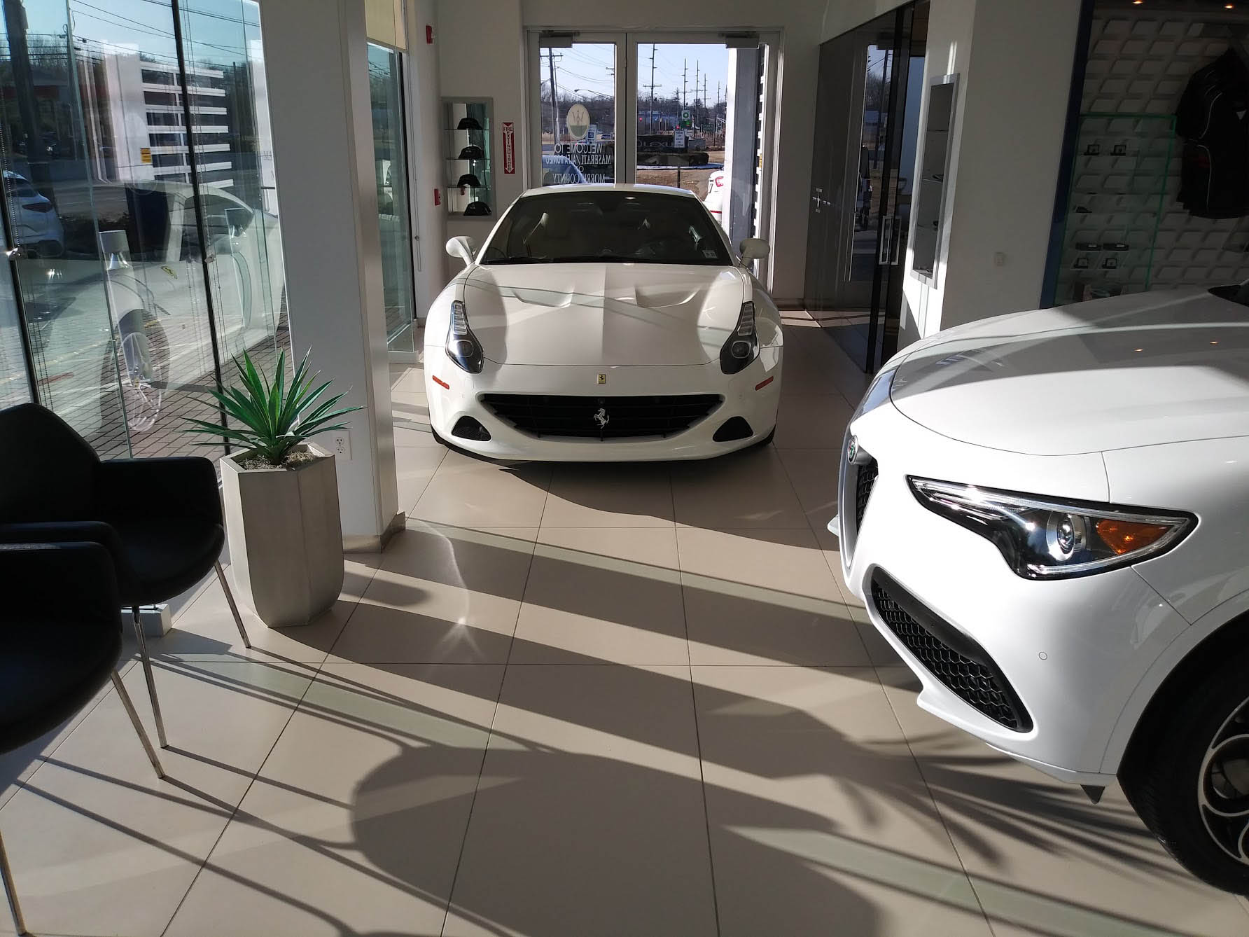 White Ferrari parked inside a Maserati dealership